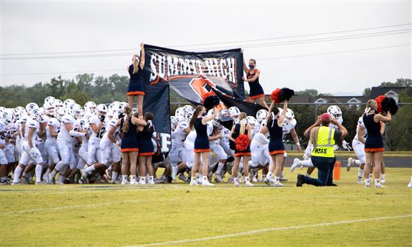Summit High football team runs through banner
